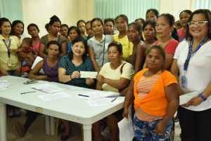 DSWD-7 Regional Director Ma. Evelyn Macapobre (Green colored print blouse) hands-over a cheque worth Php 460,000.00 to 23 Modified Conditional Cash Transfer (MCCT) Homeless Street Families of Brgy. Umapad, Mandaue City.